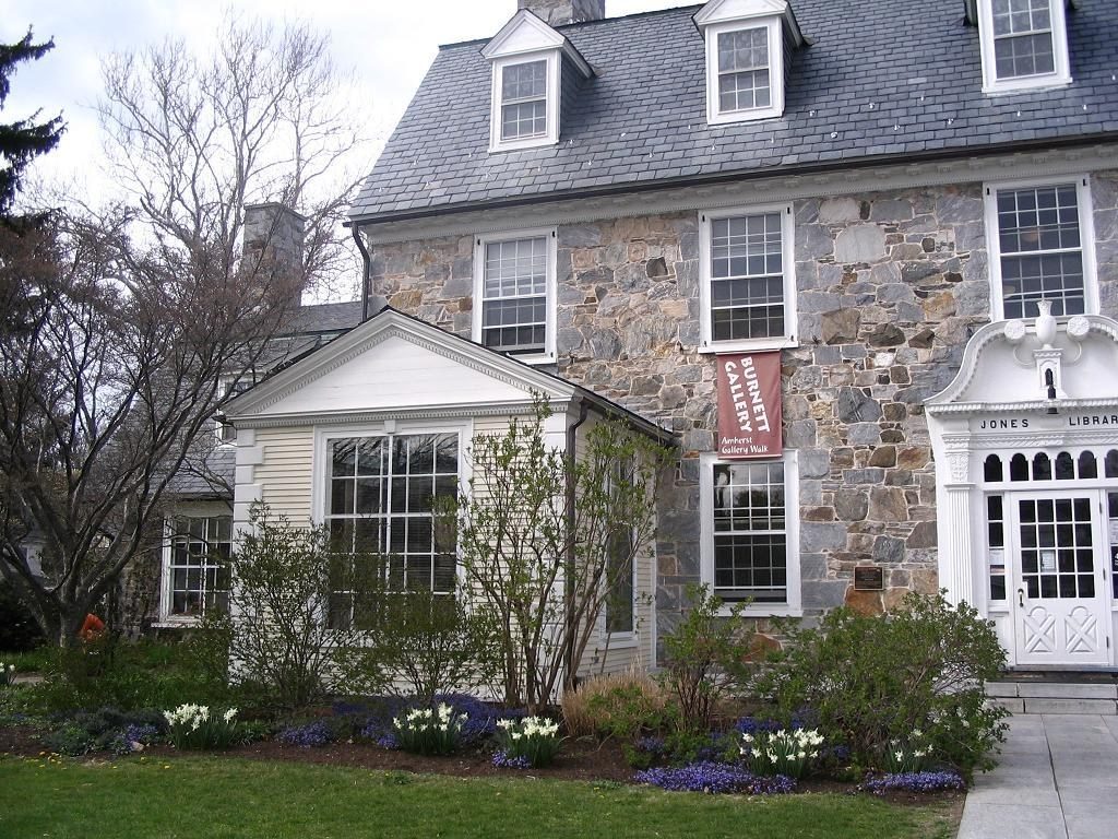 Stone house with white trim and a flowering front garden